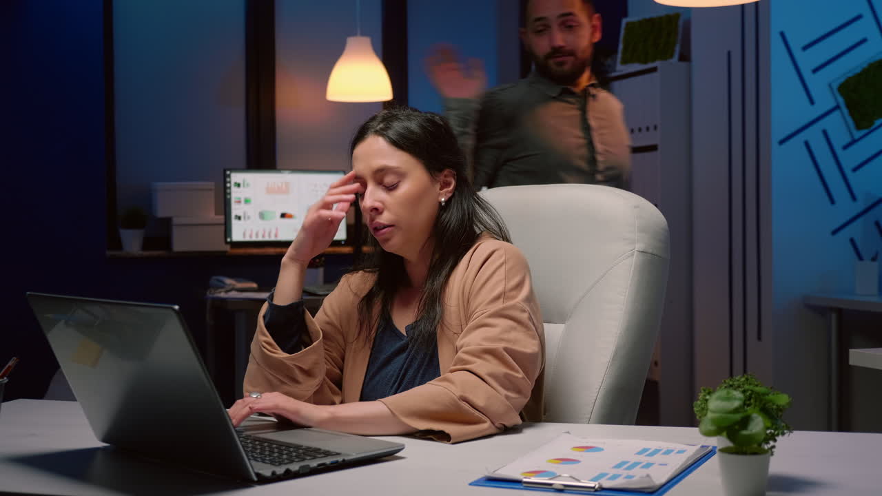 Exhausted businesswoman analyzing marketing statistics on laptop computer