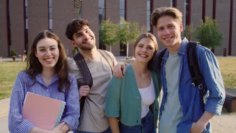 Portrait-of-group-of-four--caucasian-university-students-sitting-outside-the-university-campus