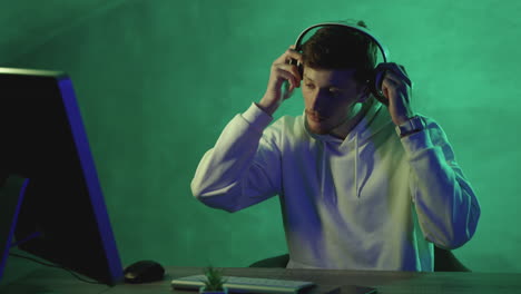 Man-working-with-a-computer-and-wireless-headphones-on-a-colorful-background