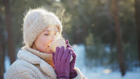 woman enjoying a hot drink in a snowy forest