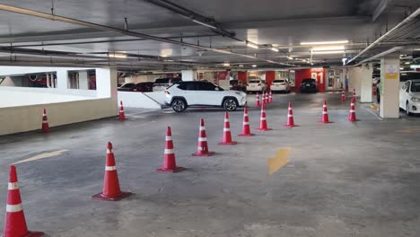 underground parking garage with cars and traffic cones