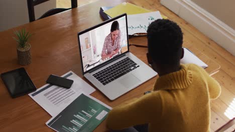 african american female teacher using laptop on video call with female student