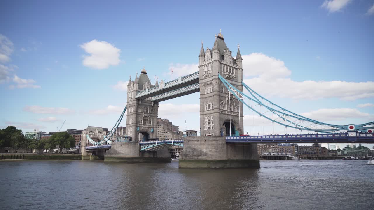 Plane flying over Iconic Tower Bridge in London full of people and cars, wide angle view, sunny day