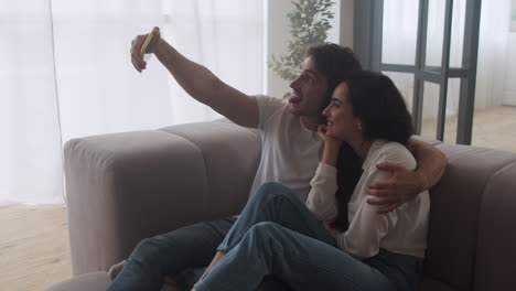 Pareja-Feliz-Haciendo-Fotos-Selfie-En-Casa.-Hombre-Y-Mujer-Sonrientes-Tomando-Fotos