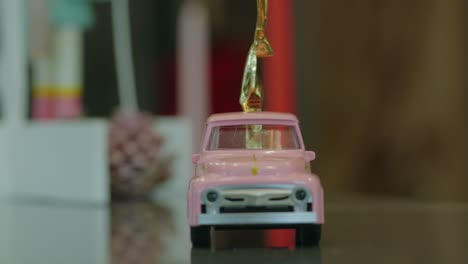 close-up of a pink toy truck topped with a shiny golden accent