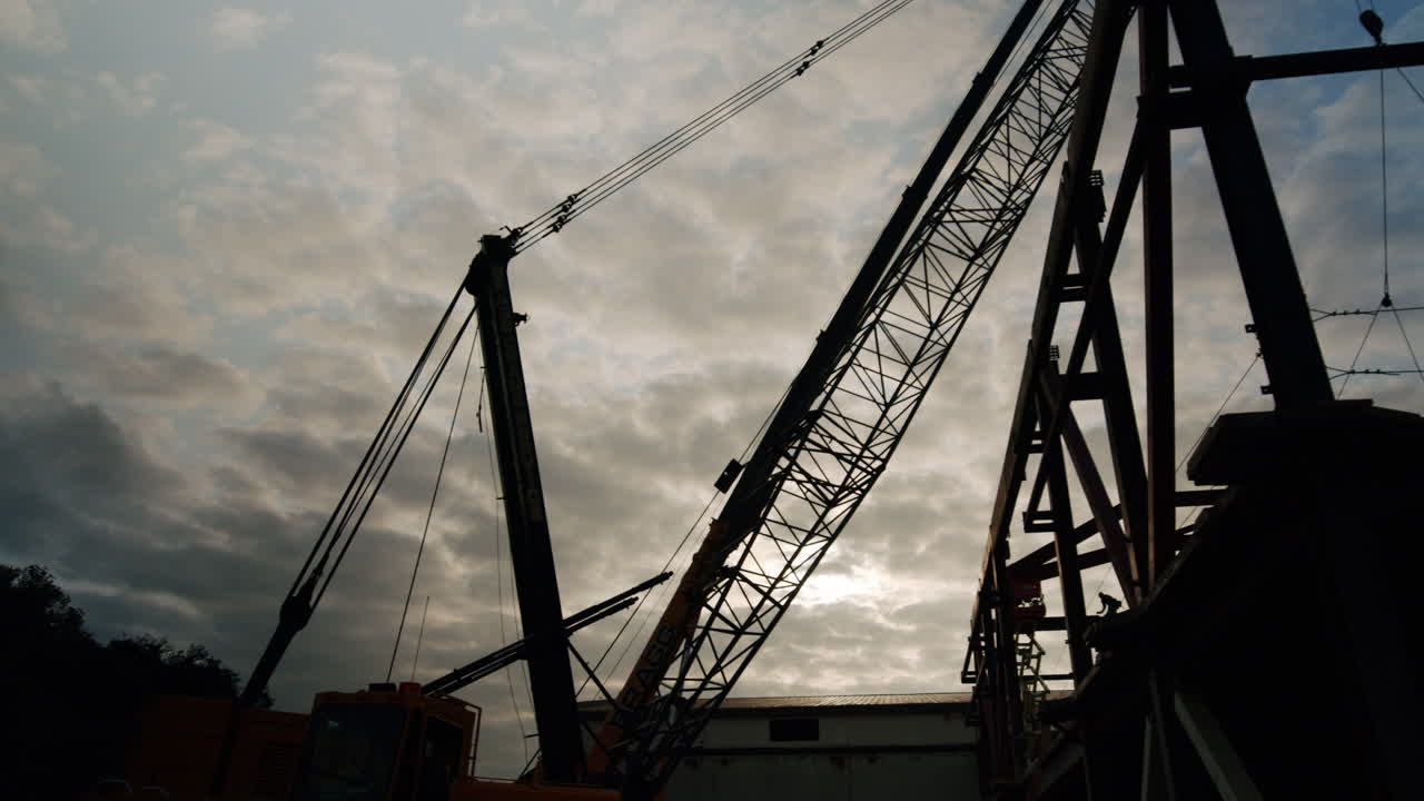 Silhouette of a large crane against a cloudy sky