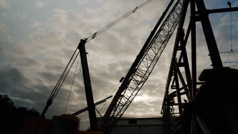 silhouette of a large crane against a cloudy sky