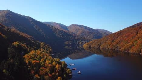 Schiebeluftaufnahme-Des-Sees-Tarnita,-Rumänien,-Umgeben-Von-Bunten-Herbstbäumen