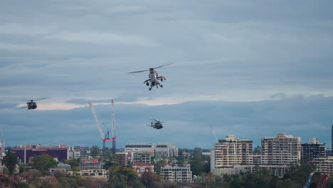 convoy of military helicopters flying over brisbane city during riverfire, 4k slow motion