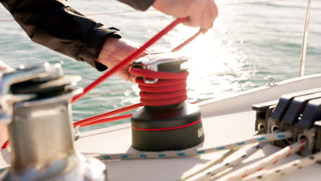 manos de marinero, cuerda y barco en el océano