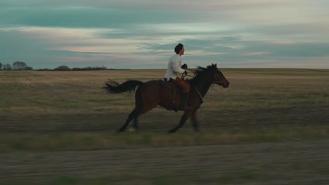 Hombre-Galopando-Un-Caballo-En-Un-Campo