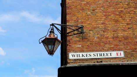 Architectural-concept-of-an-old-streetlight-hanging-in-a-facade-of-a-building-in-London,-UK