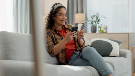 happy woman, phone and credit card on sofa