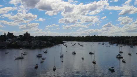 Rising-Drone-shot-of-Boats-anchored-off-a-beach-surrounded-by-suburbs