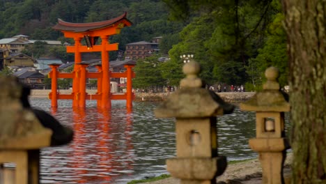 sunset panning back view bay of the great giant red torii of itsukushima shrine temple at miyajima hiroshima japan lanterns view