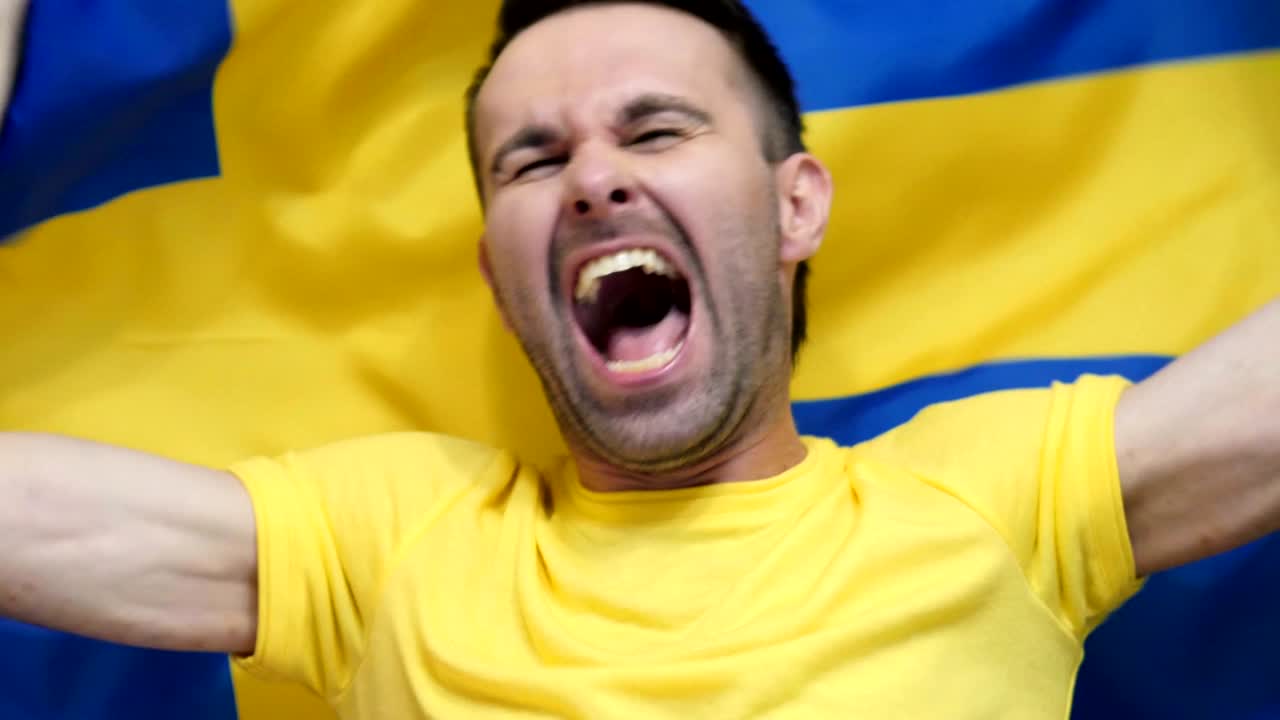 스웨덴 팬이 스웨덴의 발을 들고 축하하는 느린 동작, 4k, 고품질