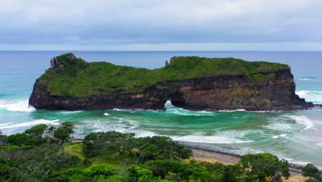 Waves-crashing-in-Hole-in-the-Wall-Transeki-Rock-formation-in-ocean-with-green-grass