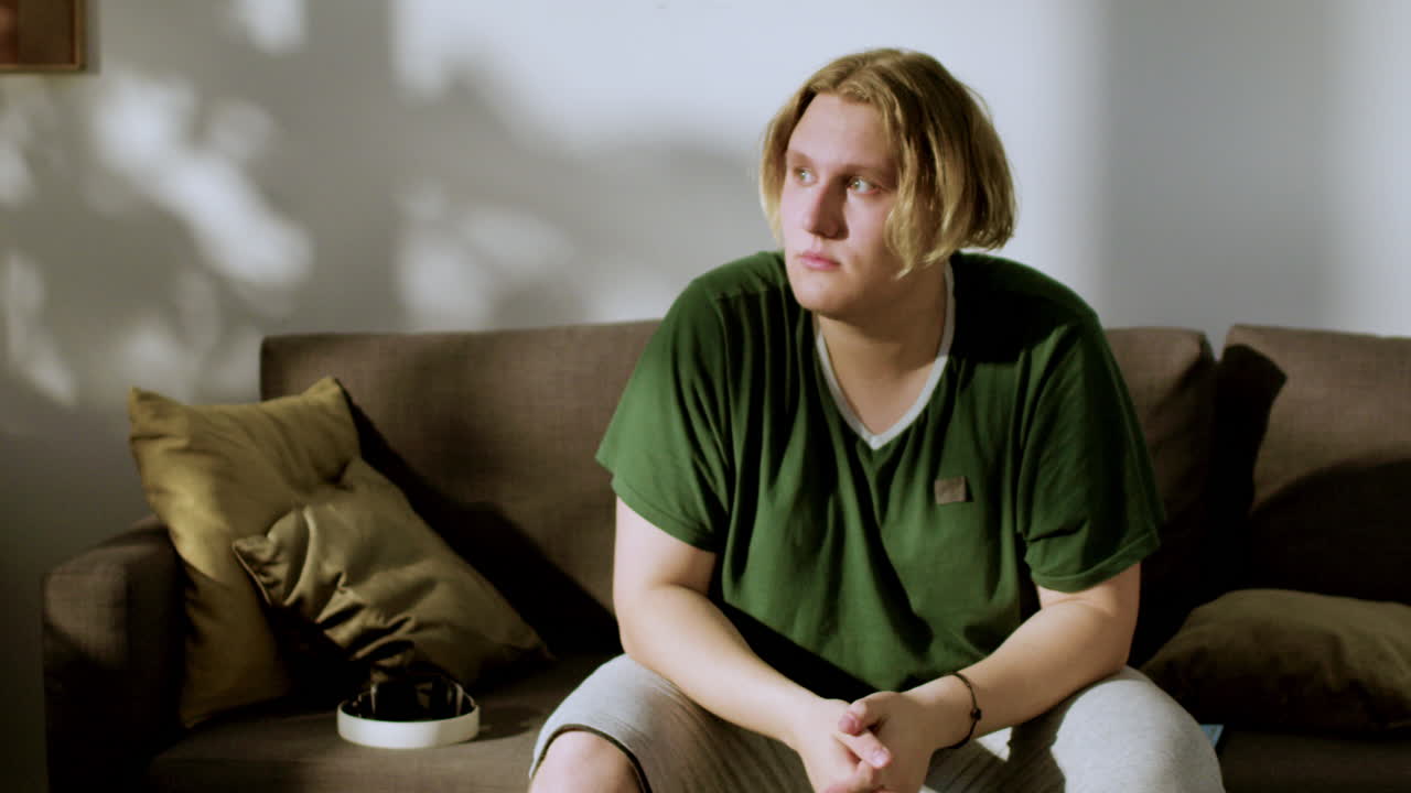 молодой человек смотрит в окно и впереди в конце