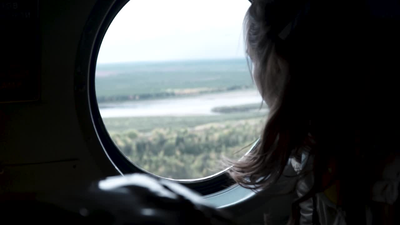 비행기 창문 밖을 바라보는 소녀