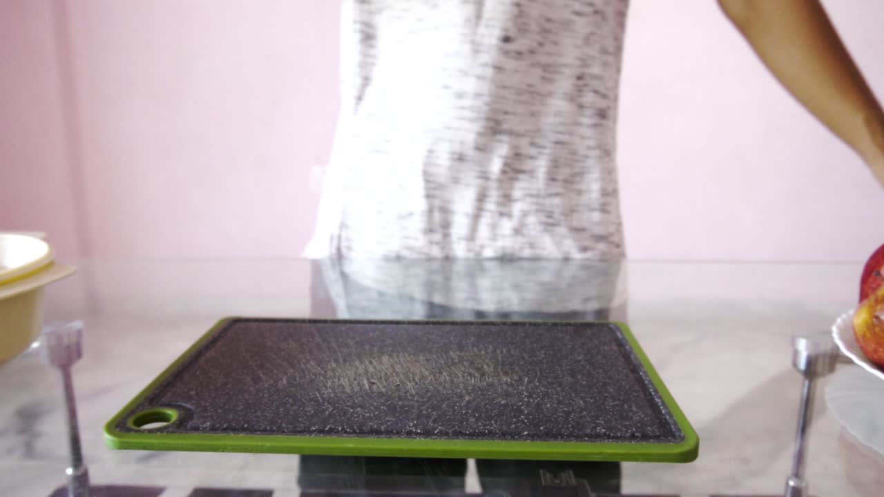 Young man with chopping board and chopping knife making salad