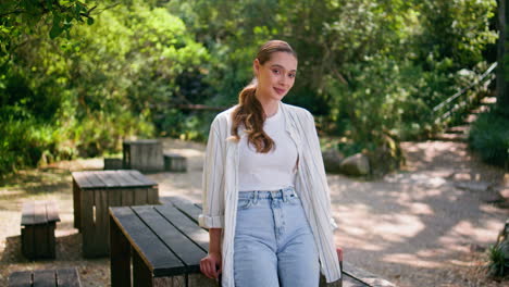 young lady posing recreation forest place leaning on table. woman standing park