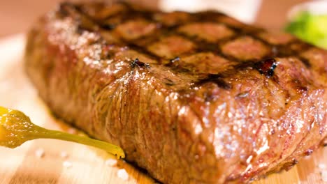 bistec grande a la parrilla, hay humo de las brasas a la carne, vista lateral, primer plano 4k bistec con una vista muy sabrosa 4k