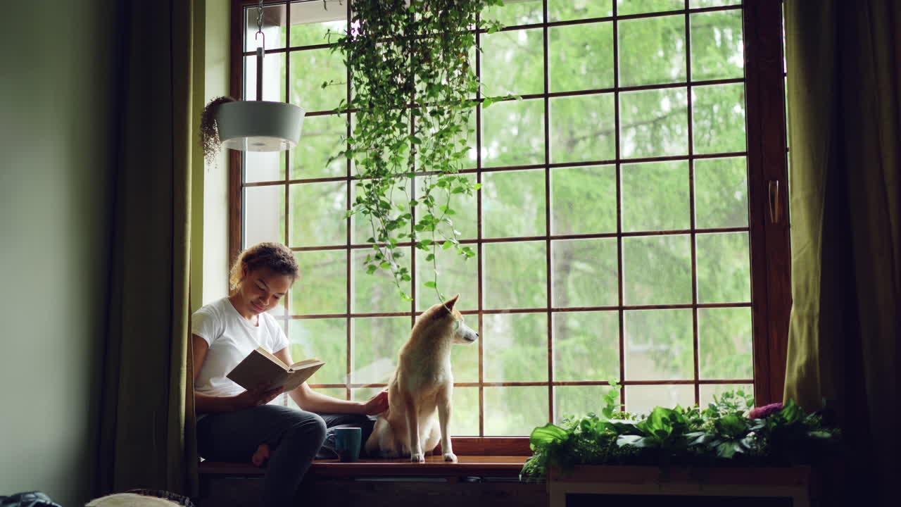 Woman Reading with Dog by the Window