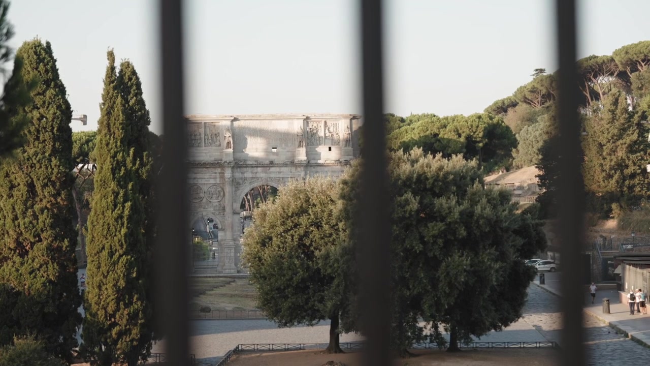 Streta via di Roma incorniciata da alberi alti e architettura storica in Italia.