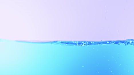 슬로우 모션의 깨끗한 물 표면은 물이 튀는 상점으로 화면을 채우고 기포로 액체 표면을 흔들고 있습니다.