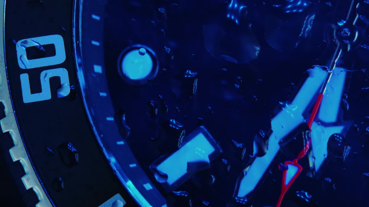 일본의 남성 크로노그래프는 사파이어 유리로 된 금속으로 만들어졌습니다. 손목 시계 - 느린 움직임, 시간이 천천히 지나가는 - 유리 위에 작은 물방울이있는 아름다운 매크로