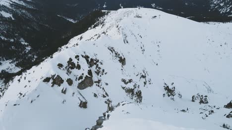 Toma-Panorámica-A-Cámara-Lenta-De-Drones-Aéreos-De-Los-Picos-Montañosos-De-Pirin-En-La-Nieve-Invernal