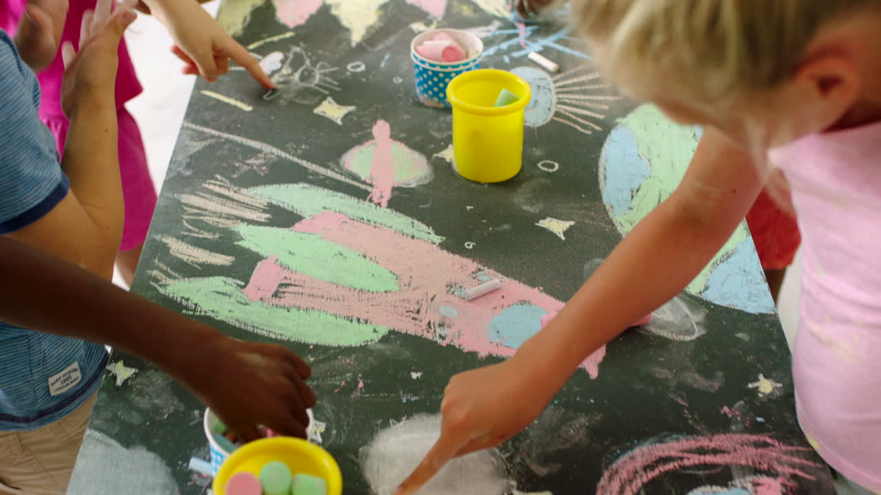 Children Drawing with Chalk on a Table