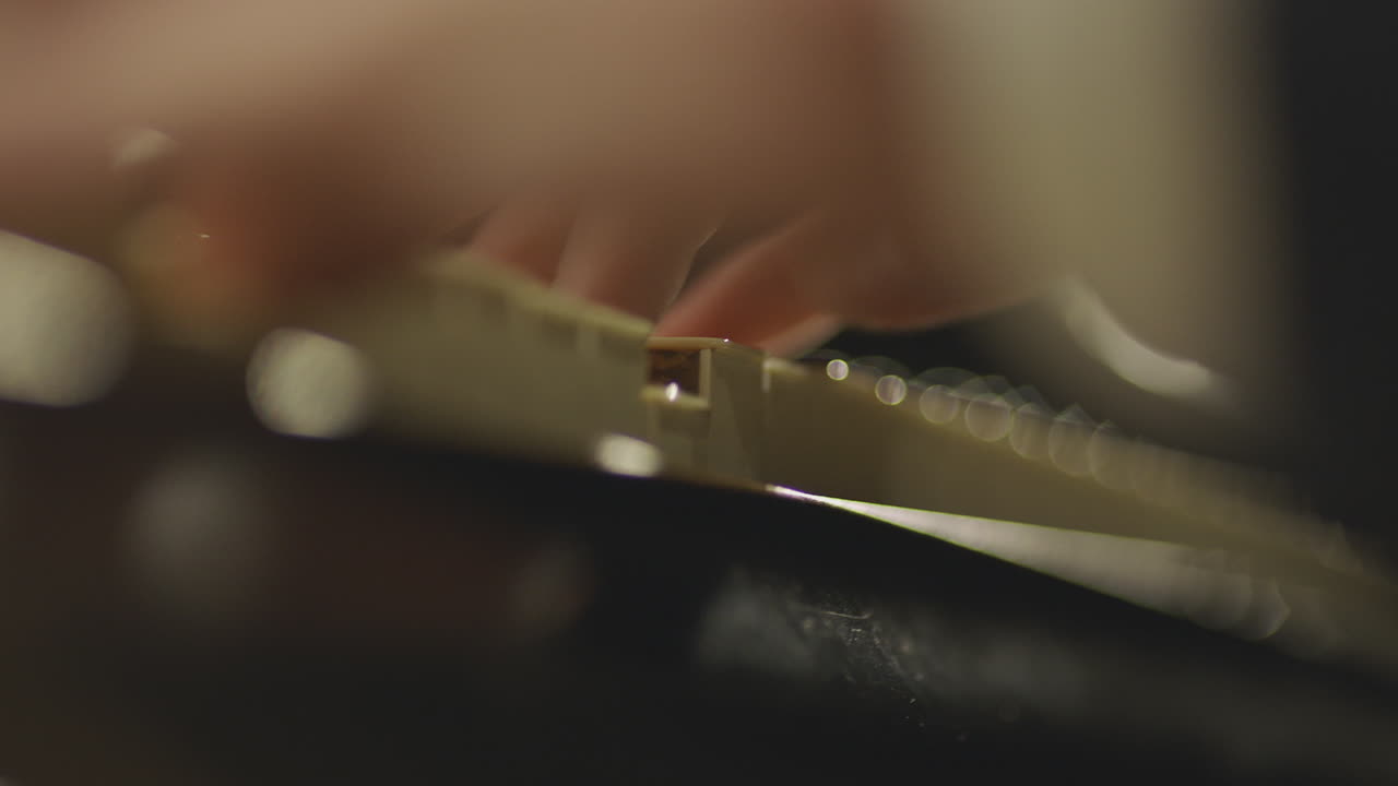 Fingers press down on the keys of a piano