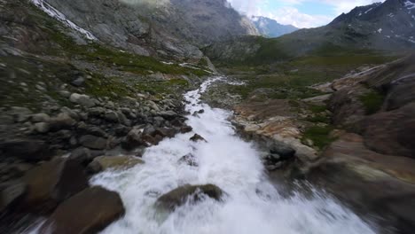 flying over water stream flowing in valmalenco valley of valtellina, italy