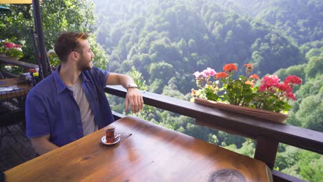 Junger-Mann-Sitzt-Im-Terrassencafé-Des-Waldes.