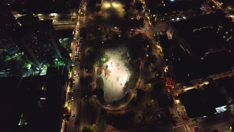 Aerial-Panoramic-360-View-Above-Bustamante-Park-at-Night-Barrio-Italia-Santiago,-Chile-Historical-Neighborhood,-Roads-with-Car-Traffic