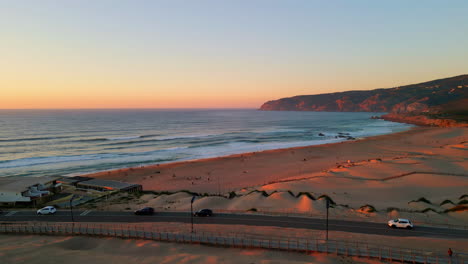 pink horizon beautiful ocean with calm waves rolling on shore. aerial view road