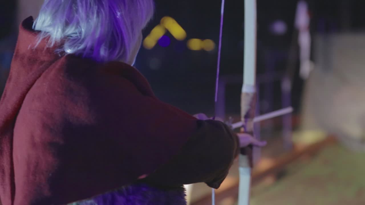 Medieval Archer Woman Use A Bow And Arrow. VINNITSA, UKRAINE, MARCH 2017: Medieval archer woman, she wearing a historical costume and use a bow and arrow