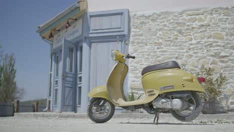 vintage yellow scooter in front of a blue building