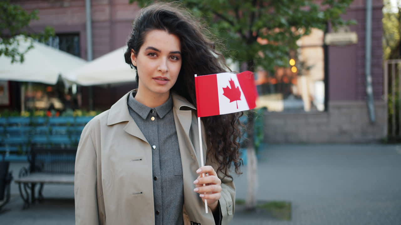 Mujer sosteniendo la bandera canadiense en la ciudad