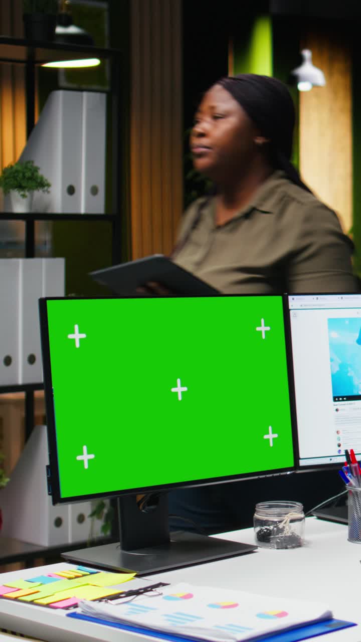 Vertical Video Mockup next to professional male editor checking PC reels on software in office