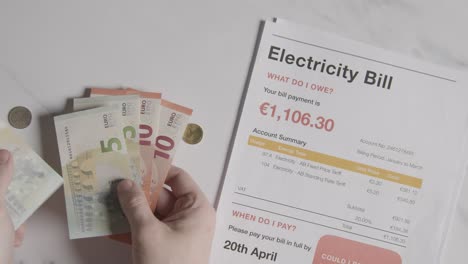 hand counting currency in euros to pay for european electricity energy bill 1