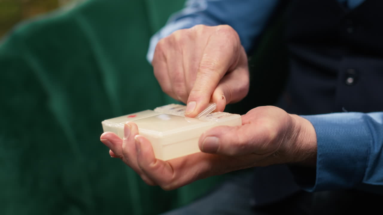 Close up of male pensioner taking capsules out of vial to manage healthcare