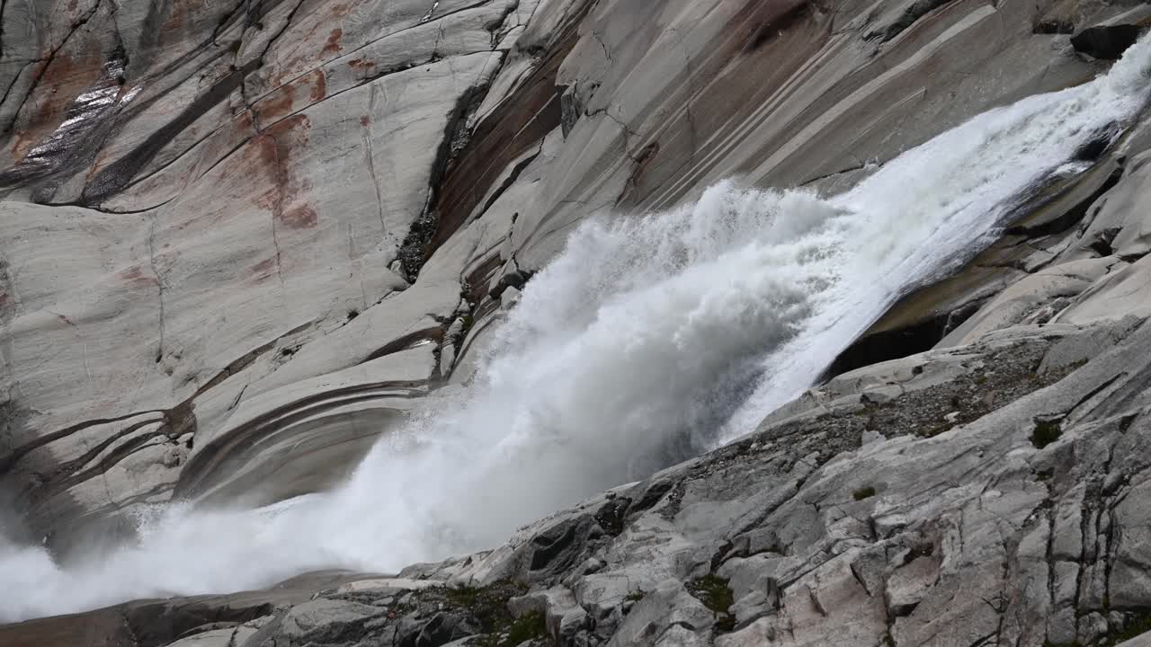Rhone powerful waterfall in rocks near its glacier source at the top of the Alps, Valais, Switzerland