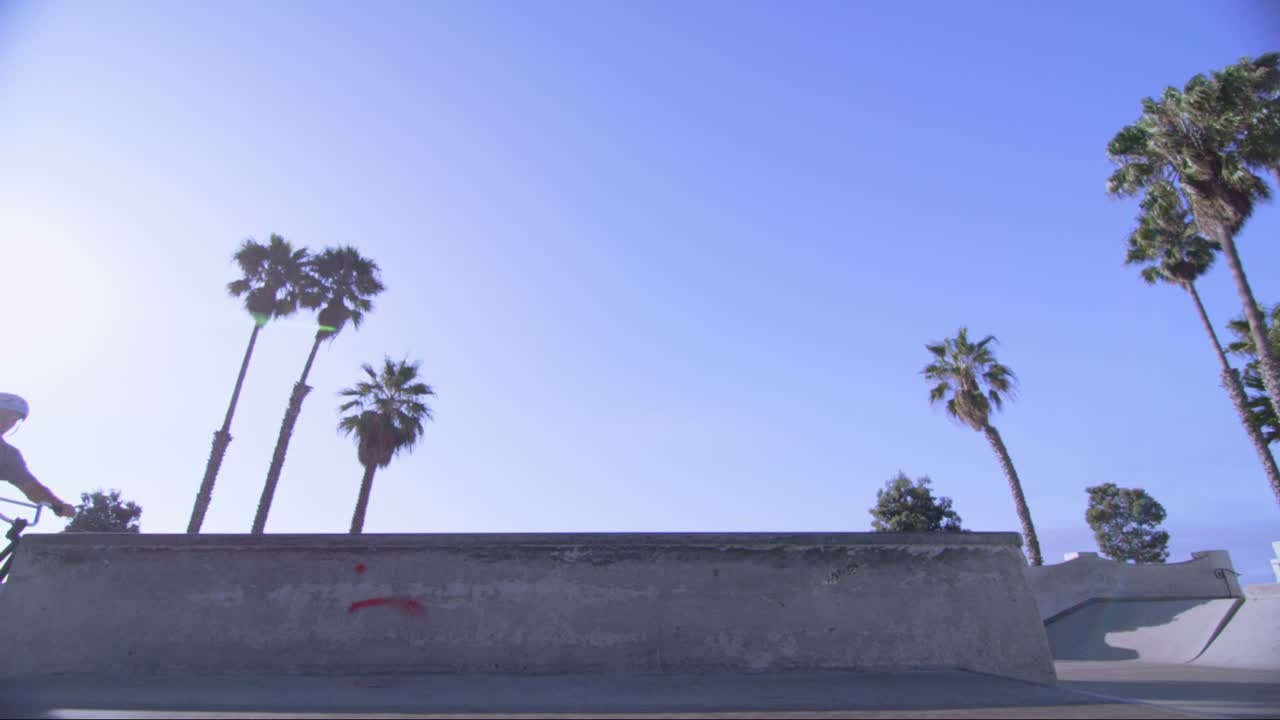vista de ángulo bajo de un ciclista de bmx haciendo un caballito en un skatepark