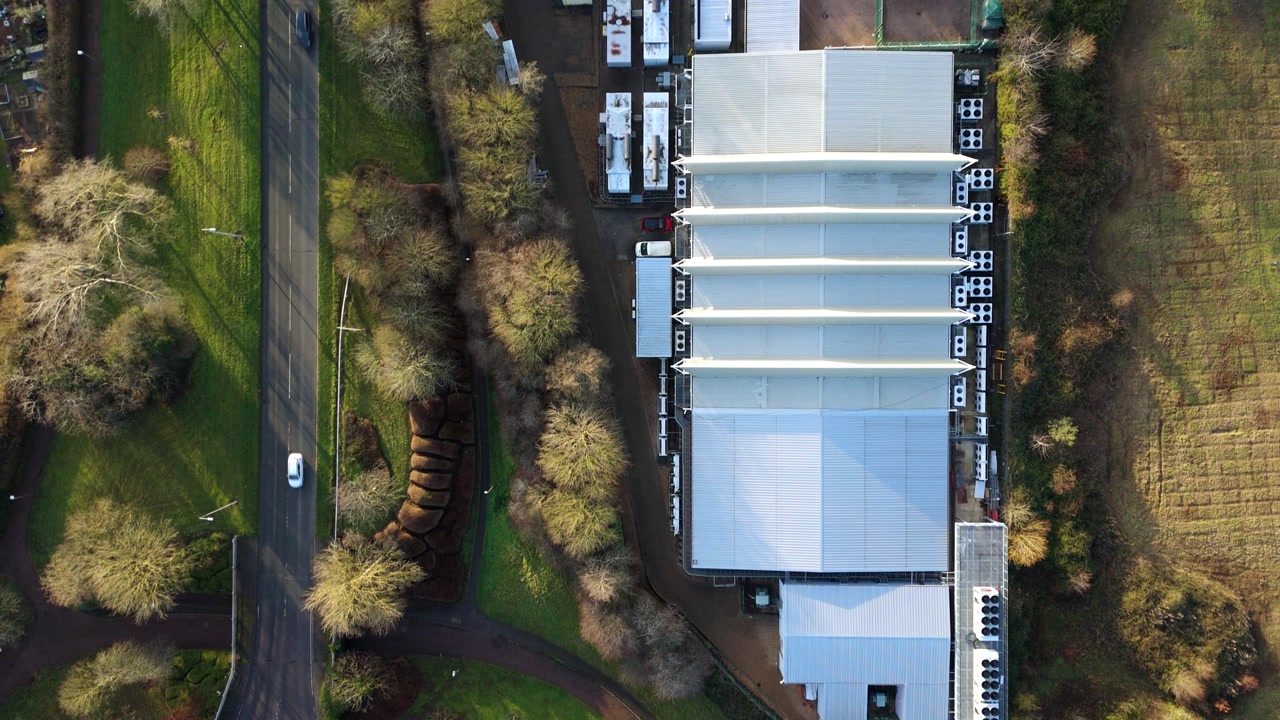 Drone view of the intricate cooling fans and external ventilation systems of a Milton Keynes AI data hub.