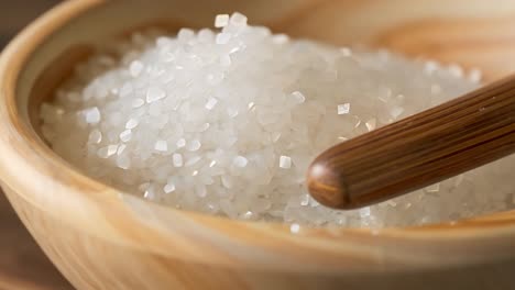 close up of uncooked white rice in a wooden bowl