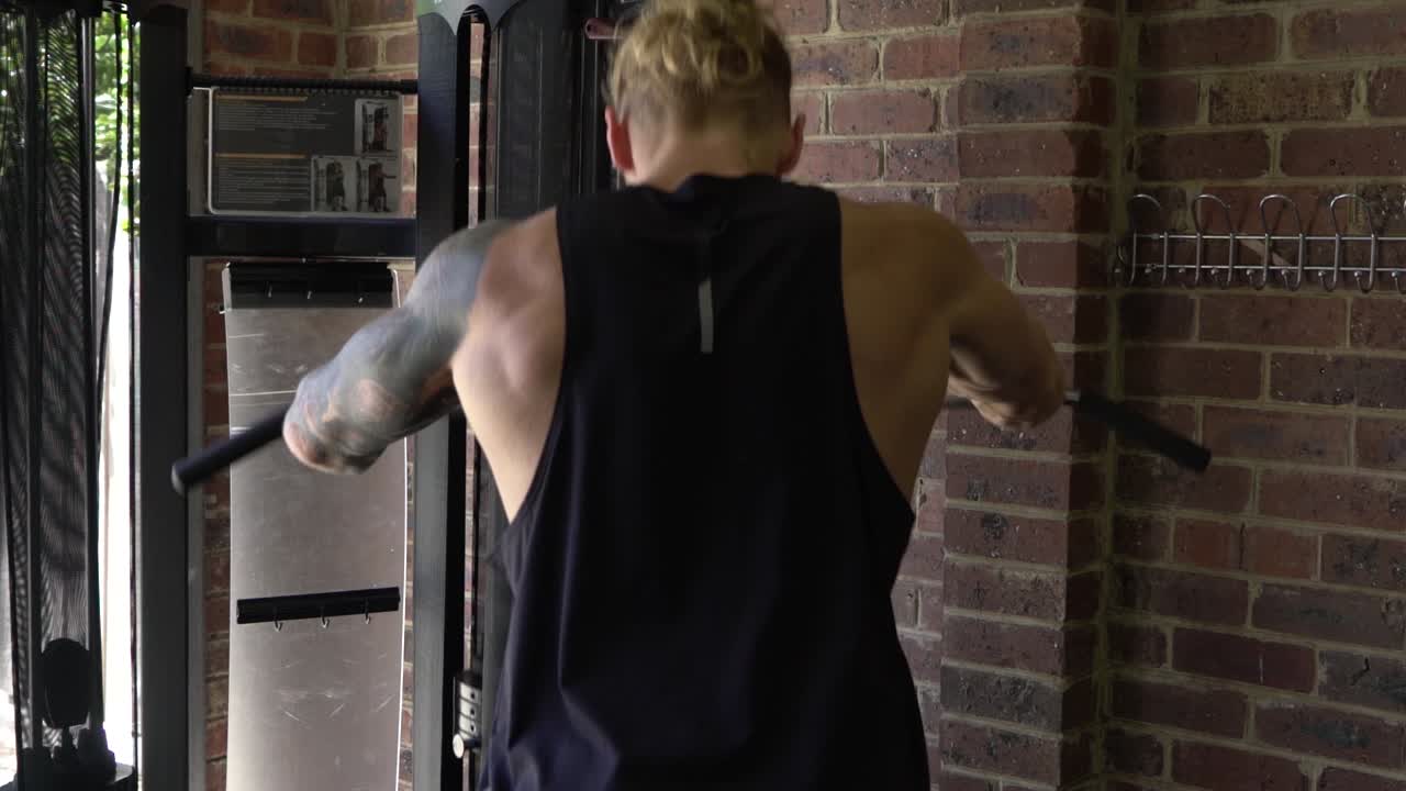 다시 서스터 운동 케이블 기계를 운동하는 홈 체육관에서 근육질의 남자