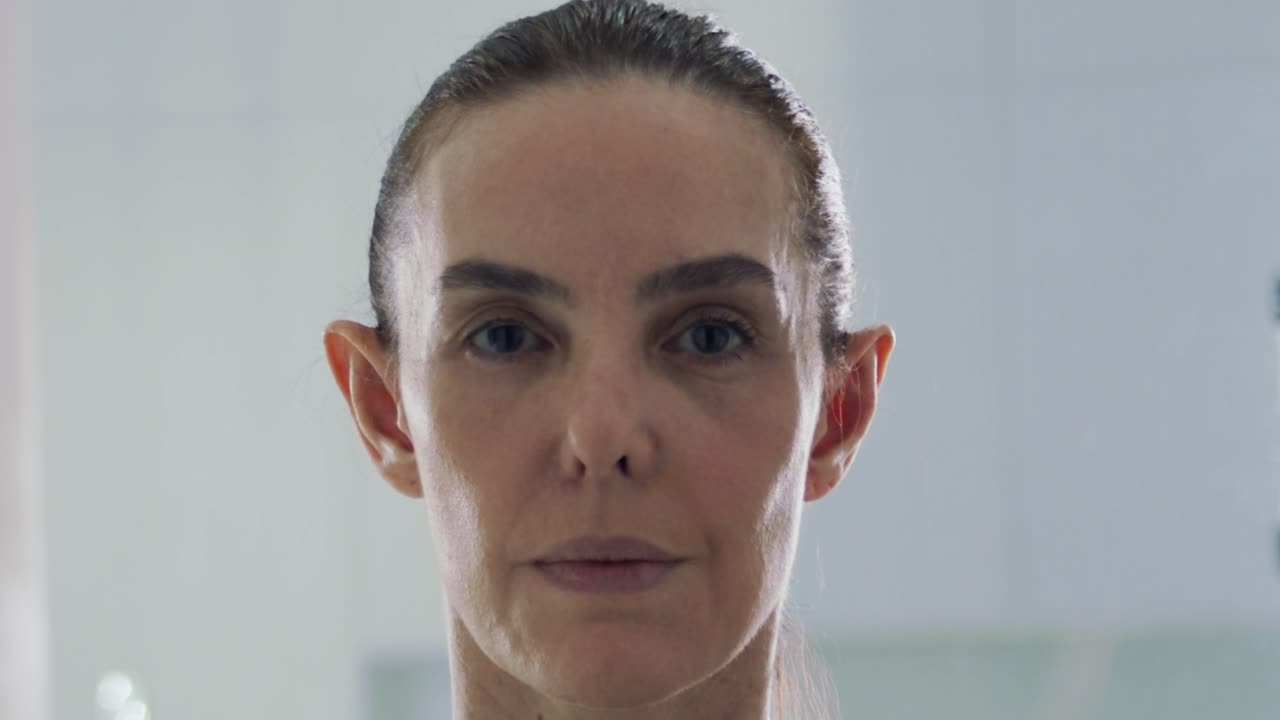 카메라를 똑바로 바라보며 머리를 뒤로 젖힌 여성의 얼굴 클로즈업 샷