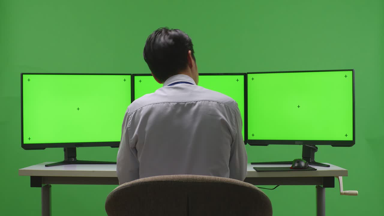 persona sobrecargada de trabajo con múltiples monitores